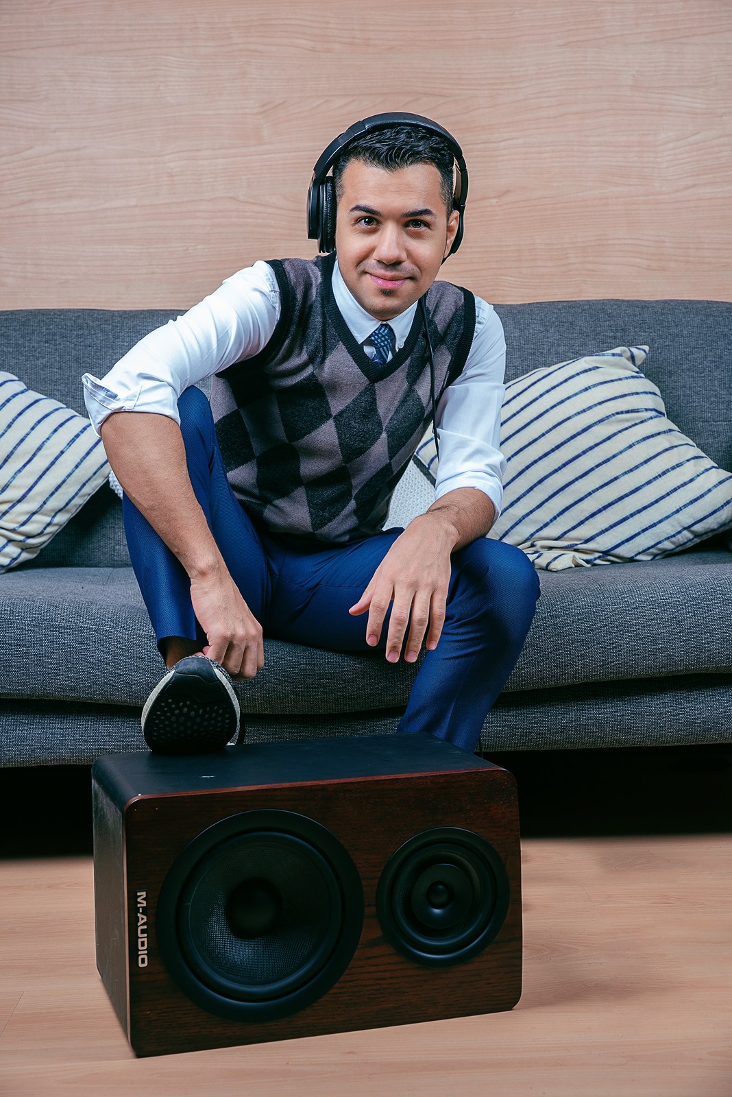Hussain Alarab wearing headphones and seated on a studio sofa